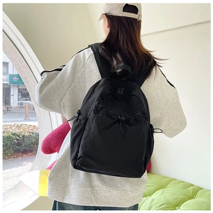 Detail of a large black nylon backpack with drawstring closure for daily commuting