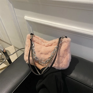 Sac à main en peluche rose avec matelassage cœur et chaîne argentée sur siège en cuir