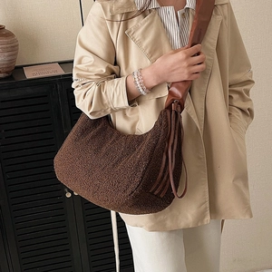 Brown fluffy lambskin crossbody bag with wide leather strap and tassel detail