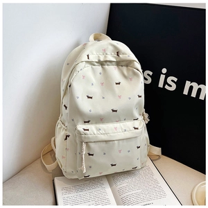 Détail du sac à dos en toile crème avec motifs de teckels et poche avant zippée
