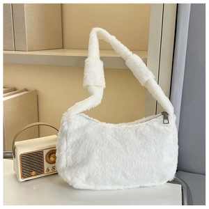 Detail of white faux fur shoulder bag with decorative knotted strap and metal zipper