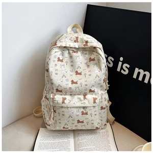 Détail du sac à dos beige pour étudiants avec motifs imprimés de chiens et de nœuds papillon