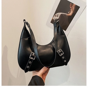 Detailansicht der schwarzen Lackleder-Halbmondtasche mit dekorativen Schnallenriemen