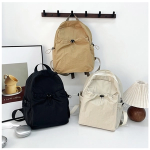Detailed view of large capacity nylon backpacks in black, khaki, and cream with drawstring pockets