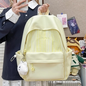 Detail of yellow striped student backpack with cute plush sheep keychain and star zipper