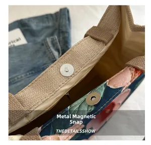 Close-up of the canvas tote bag showing high-quality metal magnetic clasp and floral pattern
