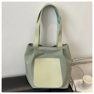 Close-up of sage green tote bag with contrasting light green pocket and BUDBAO logo