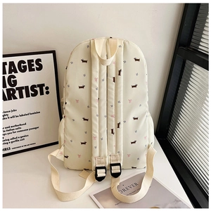 Détail de l'imprimé teckel mignon sur sac à dos en toile blanc cassé avec bretelles