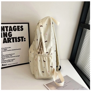 Détail d'un sac à dos crème avec motifs teckels et nœuds roses et poches latérales pratiques
