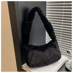 Close-up of the plush black faux fur texture and wide shoulder strap of the baguette bag