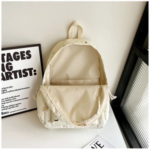 Vue détaillée de l'intérieur d'un sac à dos en toile crème avec motifs de chiens et de fleurs