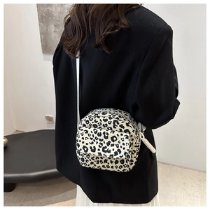 Detail of small leopard print crossbody bag with woven rope knots on the shoulder strap