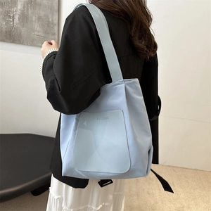 Minimalist light blue nylon tote bag with shoulder strap and stylish exterior pocket