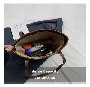 Dettaglio interno di una borsa tote in pelle marrone con grande capacità per cosmetici