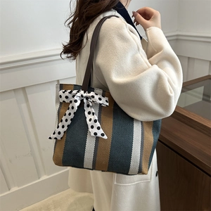 Striped canvas tote bag with polka dot bow accent and large capacity for daily use