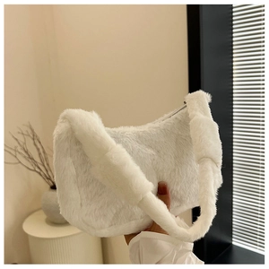 Close-up of white plush hobo bag with soft faux fur texture and matching shoulder strap
