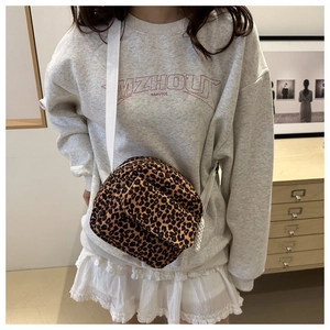Detail of leopard print crossbody bag with white canvas strap and side tassel decoration