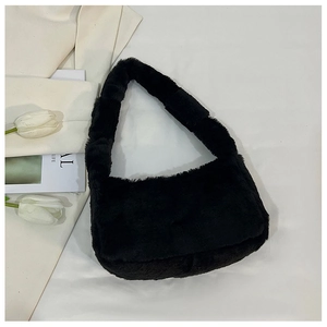 Detail of plush black faux fur shoulder bag with soft texture on white background