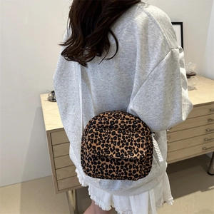 Chic leopard print crossbody bag with white woven rope strap shown on a model