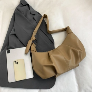 Detail of khaki pleated dumpling bag showing lychee leather texture and knot shoulder strap