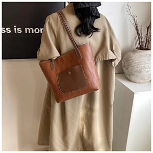 Vista posteriore di una borsa tote in pelle marrone con patchwork verticale e tracolla