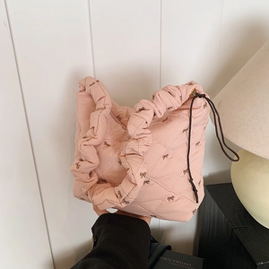 Pink quilted tote bag with embroidered bows and ruffled handles for women's daily commute