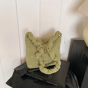 Quilted light green tote bag with white bow embroidery and ruffled handle design