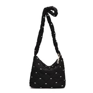 Black quilted tote bag with white bow embroidery and pleated shoulder strap design