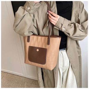 Dettaglio borsa tote patchwork kaki con tasca in pelle marrone e fibbia dorata
