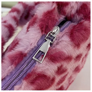 Detail of soft plush leopard print bag featuring a smooth purple zipper closure