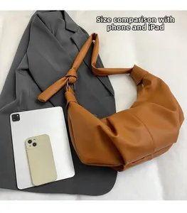 Brown pleated dumpling bag showing storage capacity for iPad and smartphone