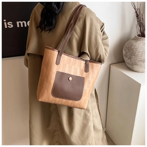 Dettaglio borsa tote kaki con goffratura a mattoni e tasca esterna in pelle marrone