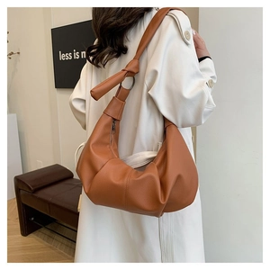 Detail of caramel lychee grain leather hobo bag with ring buckle and knot shoulder strap
