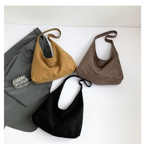 Tre borse tote minimaliste in pelle scamosciata gialla, marrone e nera su base bianca