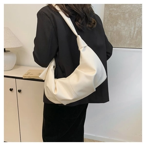 Detail of cream-colored oversized hobo bag with unique knot shoulder strap and lychee texture