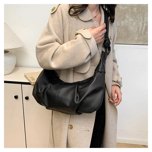 Detail of black pleated shoulder bag with lychee texture and soft vegan leather finish