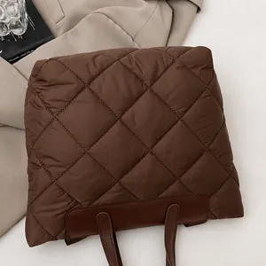 Close-up of dark brown quilted rhombic stitching on soft puffer fabric material