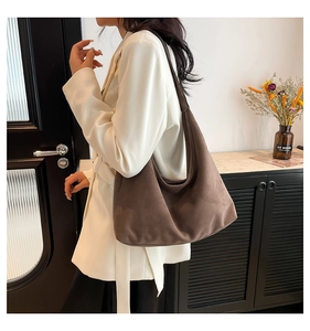 Borsa hobo in pelle scamosciata marrone sulla spalla con estetica minimalista