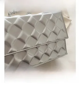 Close-up of quilted silver chain bag showing diamond texture and metallic finish