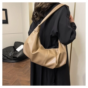 Detail of khaki lychee grain leather hobo bag featuring a knotted strap shoulder design