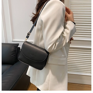 Gros plan sur un sac bandoulière noir avec boucle dorée et logo Fashion Bags gaufré