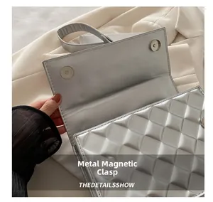 Detail of silver-grey quilted leather shoulder bag featuring a magnetic snap closure