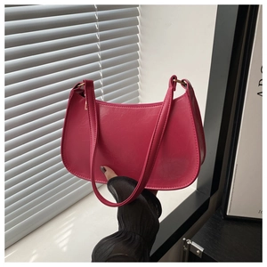 Detail of hot pink crescent underarm bag in textured faux leather with zipper