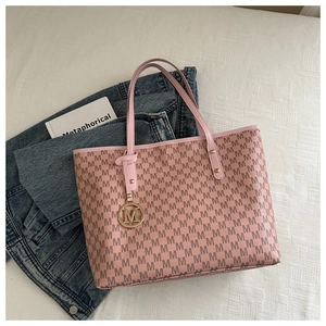 Close-up of pink tote bag with M letter print and gold metallic charm detail