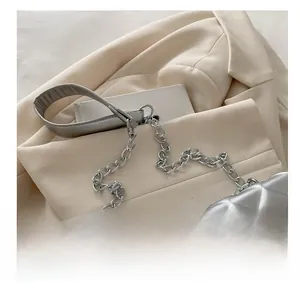 Detail of silver quilted handbag showing metal chain strap and luxury texture