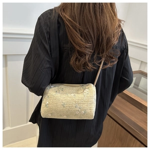 Detailed back view of a straw cylindrical shoulder bag with delicate floral embroidery