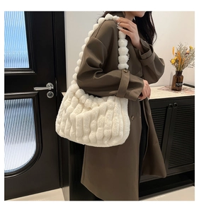 Detail of soft ivory faux fur shoulder bag with wavy cloud pleated texture and fluffy strap