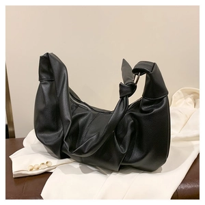 Close-up of black荔枝 grain leather dumpling bag with knotted shoulder strap and silver ring