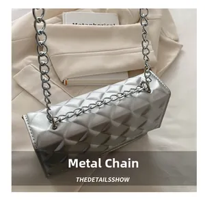 Macro detail of silver quilted pattern texture and metal chain link on the shoulder bag