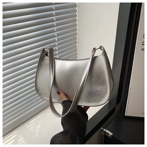 Detail of silver metallic hobo bag featuring cracked texture and golden hardware